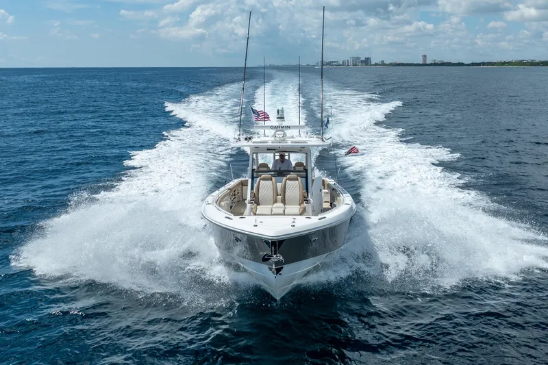 Slide: The Image of 2021 Everglades 395 Center Console boat cruising on open ocean under clear skies. - 3