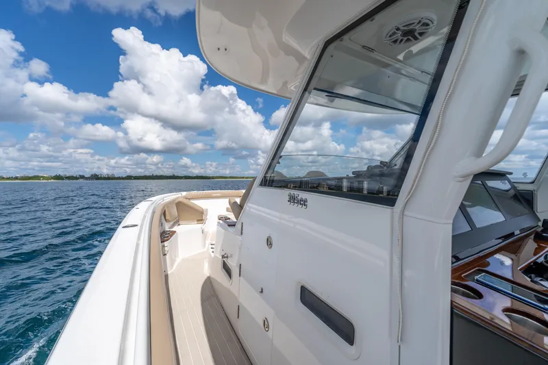 Slide: The Image of 2021 Everglades 395 Center Console boat on open water under blue sky. - 33
