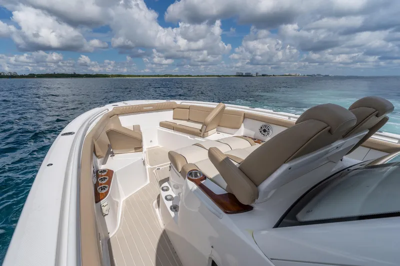 Slide: The Image of 2021 Everglades 395 Center Console boat on open water, featuring luxurious seating and clear skies. - 34