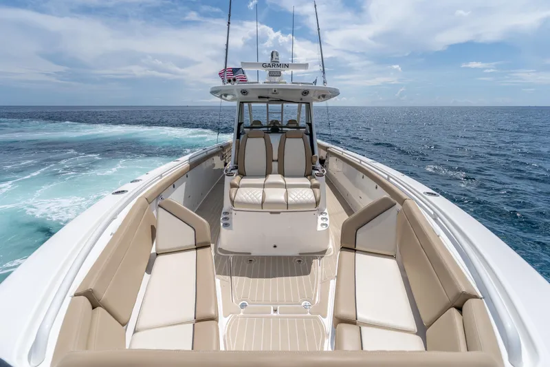Slide: The Image of 2021 Everglades 395 Center Console boat on open ocean, featuring spacious seating and modern design. - 35