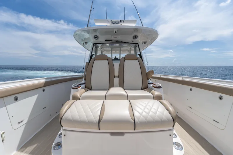 Slide: The Image of 2021 Everglades 395 Center Console boat with luxurious seating, ocean view, and clear sky. - 36