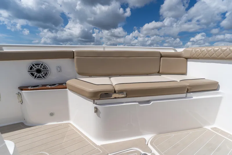 Slide: The Image of 2021 Everglades 395 Center Console boat seating with beige cushions under a cloudy sky. - 38