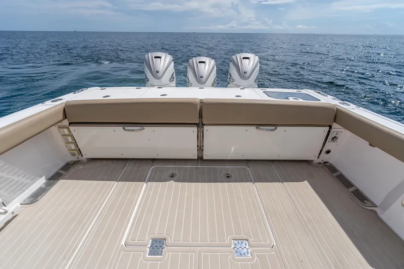 Slide: The Image of 2021 Everglades 395 Center Console boat with triple outboard engines on open sea. - 52