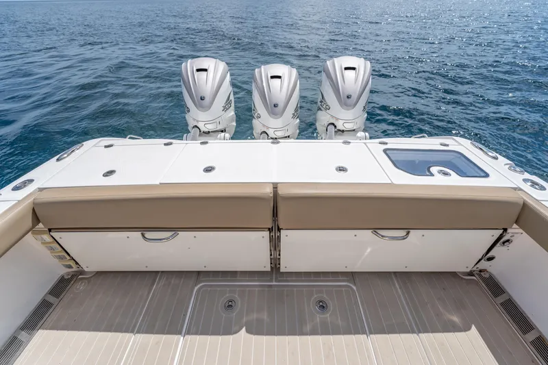Slide: The Image of 2021 Everglades 395 Center Console boat with triple outboard engines on open water. - 54