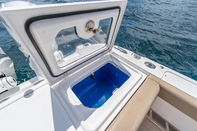 Slide: The Image of Open storage compartment on 2021 Everglades 395 Center Console boat, with ocean in background. - 55