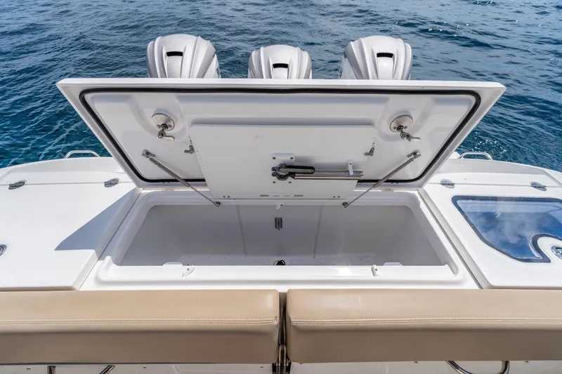 Slide: The Image of 2021 Everglades 395 Center Console boat with open storage compartment and triple engines. - 56