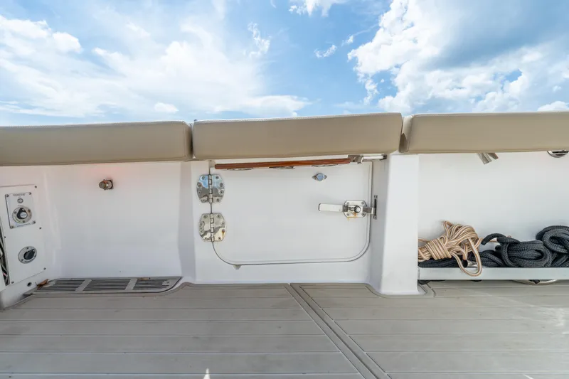 Slide: The Image of 2021 Everglades 395 Center Console boat deck with storage and seating under a blue sky. - 60