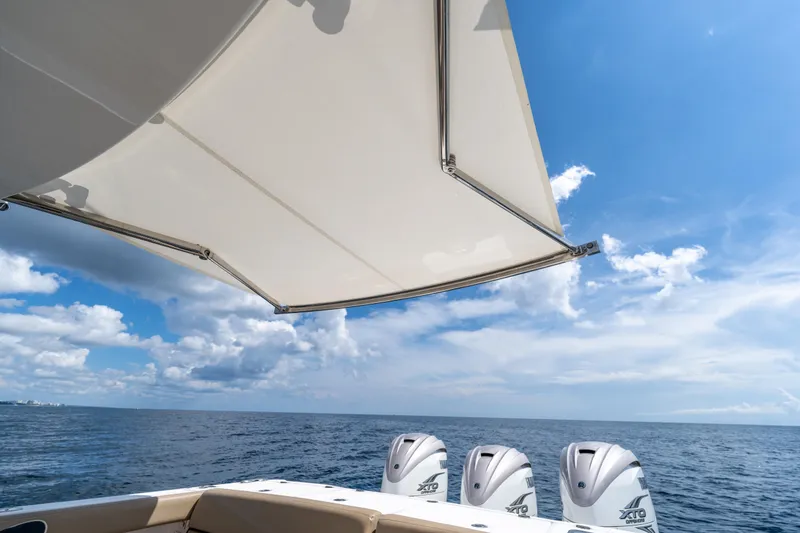 Slide: The Image of 2021 Everglades 395 Center Console boat with triple outboard engines on open sea. - 71