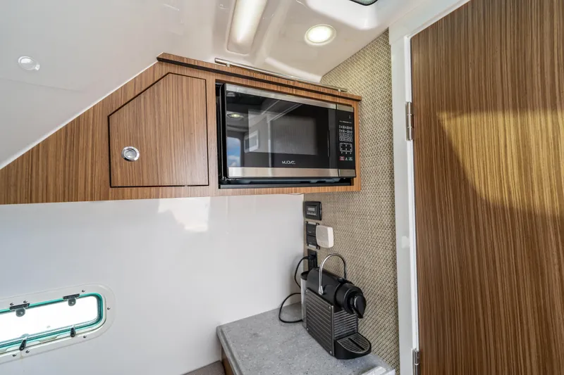 Slide: The Image of Interior of 2021 Everglades 395 Center Console with microwave and coffee maker. - 79