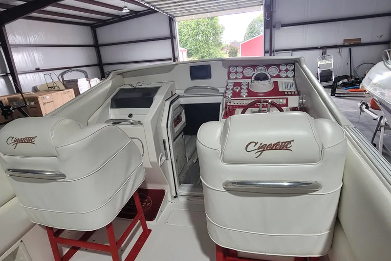 Slide: The Image of Interior of a 2000 Cigarette 35 Top Gun LE boat with white seating and red dashboard. - 12