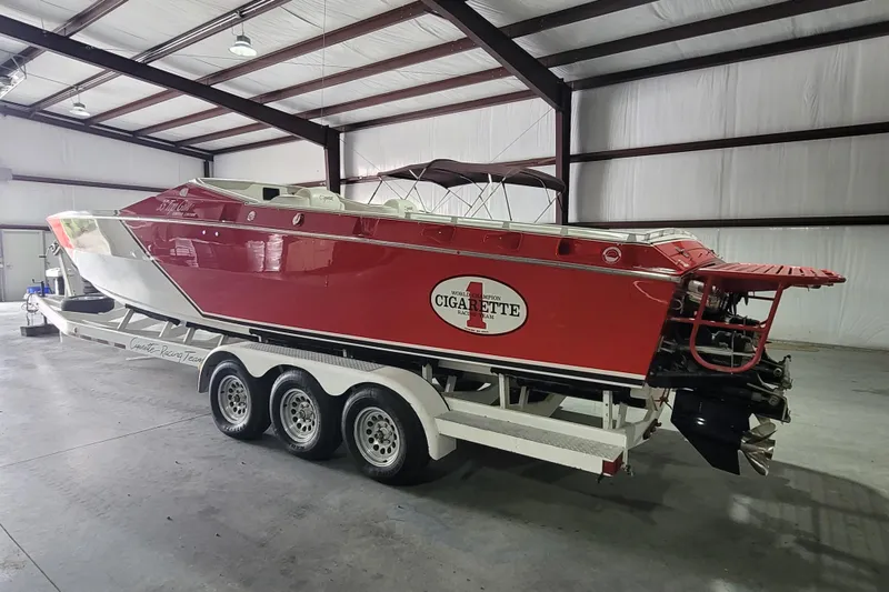 Slide: The Image of 2000 Cigarette 35 Top Gun LE boat in a warehouse on a triple-axle trailer. - 2