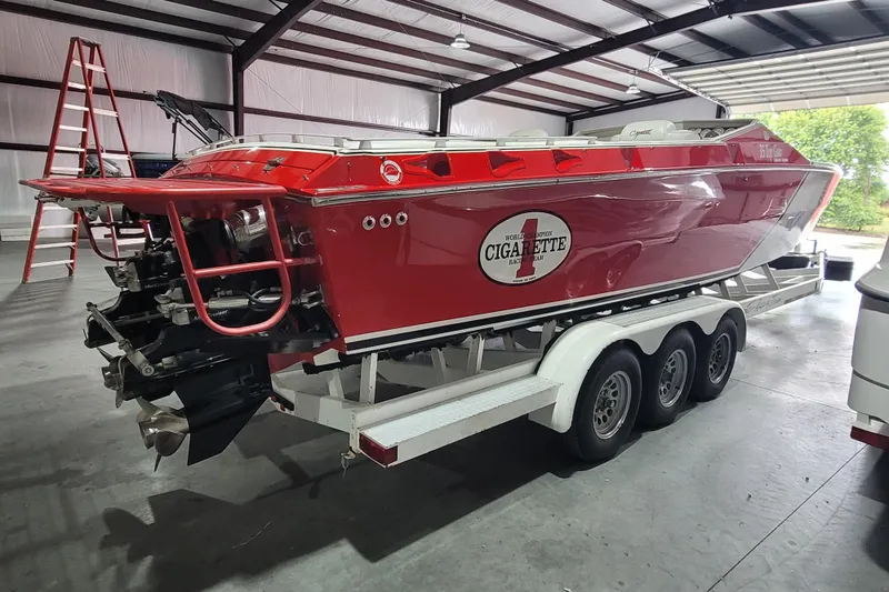 Slide: The Image of Red 2000 Cigarette 35 Top Gun LE boat on trailer in a garage setting. - 6