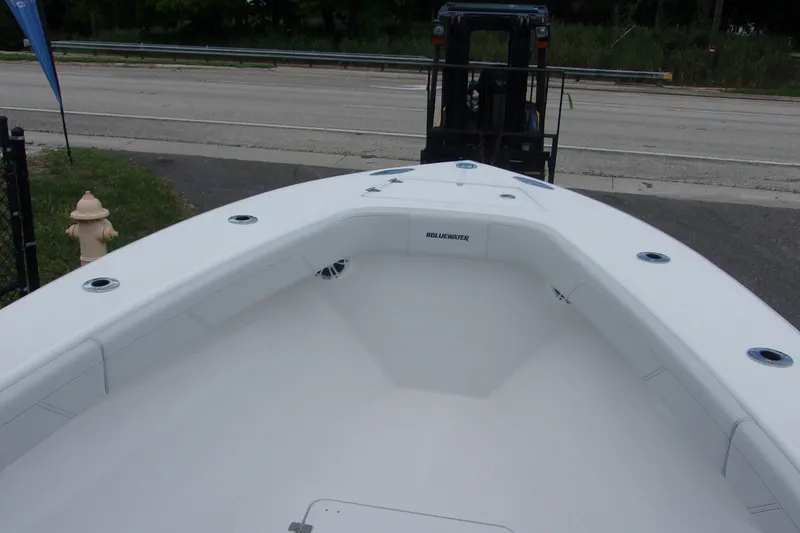 Slide: The Image of 2025 Bluewater 23 T boat interior with sleek white design and spacious seating. - 11