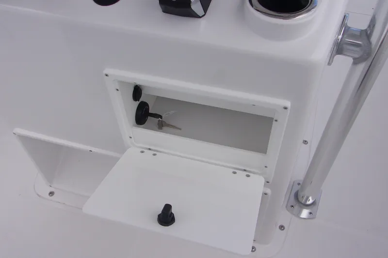 Slide: The Image of 2025 Bluewater 23 T boat console with open storage compartment and key. - 15