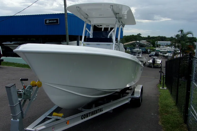 Slide: The Image of 2025 Bluewater 23 T boat on trailer at dealership, overcast sky. - 19