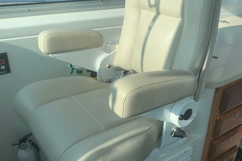 Slide: The Image of Captain's chair on 2008 Back Cove 33 Hard Top Express boat, featuring beige upholstery. - 15