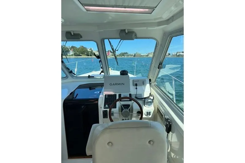 Slide: The Image of 2008 Back Cove 33 Hard Top Express helm with Garmin navigation, overlooking serene waters. - 16