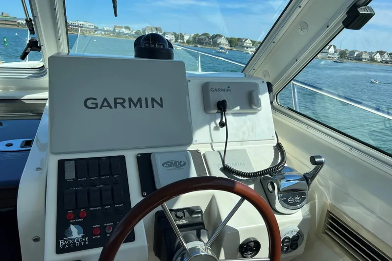 Slide: The Image of 2008 Back Cove 33 Hard Top Express helm with Garmin navigation system, overlooking scenic waterfront. - 17