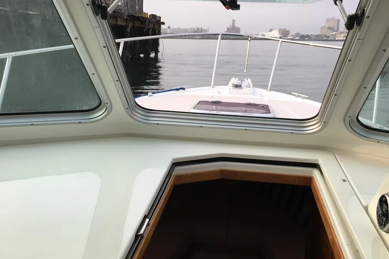 Slide: The Image of 2008 Back Cove 33 Hard Top Express boat interior view with water and cityscape. - 22