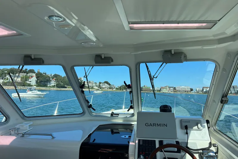 Slide: The Image of Interior view from a 2008 Back Cove 33 Hard Top Express, overlooking a coastal town. - 23