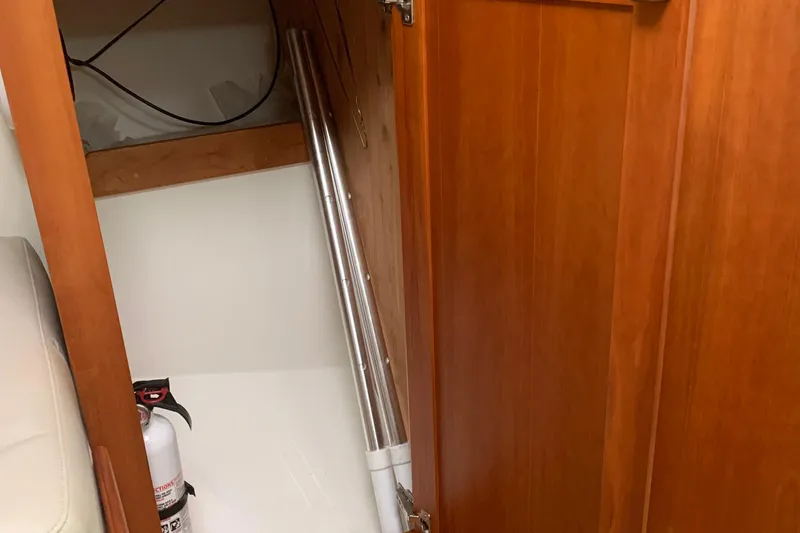 Slide: The Image of 2008 Back Cove 33 Hard Top Express interior storage with fire extinguisher and metal pole. - 27