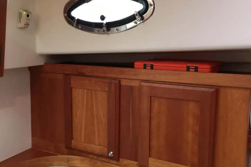 Slide: The Image of 2008 Back Cove 33 Hard Top Express interior with wooden cabinets and porthole window. - 30
