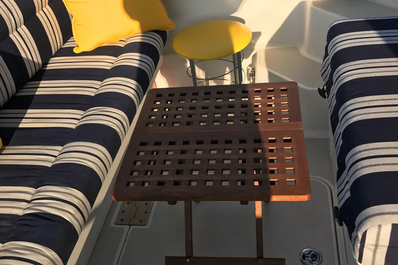 Slide: The Image of Interior of 2008 Back Cove 33 Hard Top Express with striped seating and wooden table. - 4