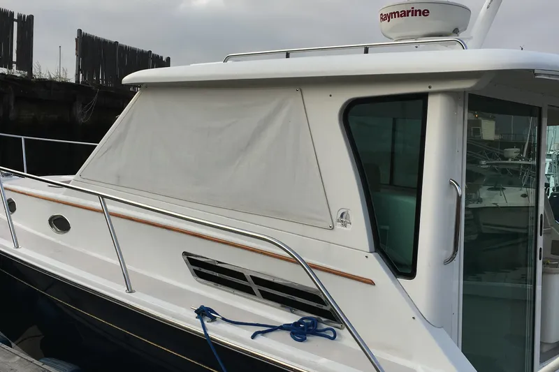 Slide: The Image of 2008 Back Cove 33 Hard Top Express boat docked, featuring sleek design and Raymarine equipment. - 8