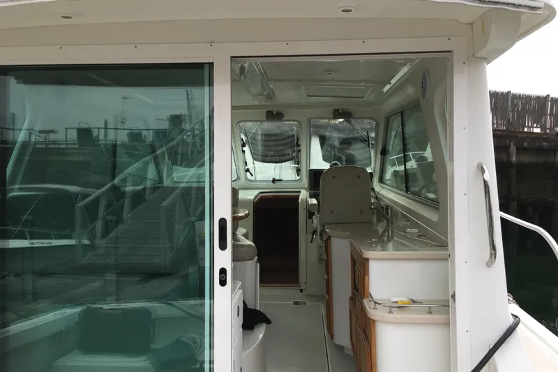 Slide: The Image of 2008 Back Cove 33 Hard Top Express interior with sliding glass door and helm station. - 9