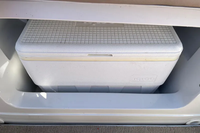 Slide: The Image of White Igloo cooler stored in a 2019 Crownline 205 SS boat compartment. - 11