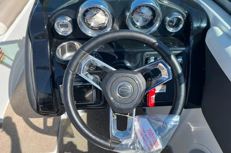 Slide: The Image of Steering wheel and dashboard of 2019 Crownline 205 SS boat, featuring gauges and controls. - 12