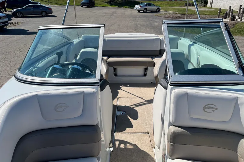 Slide: The Image of 2019 Crownline 205 SS boat interior with seating and steering wheel, parked on pavement. - 6