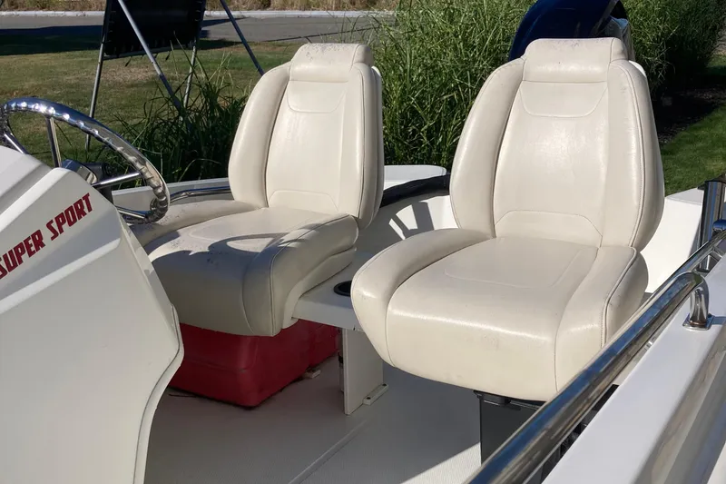 Slide: The Image of 2019 Boston Whaler 130 Super Sport boat interior with white seats and steering wheel. - 1
