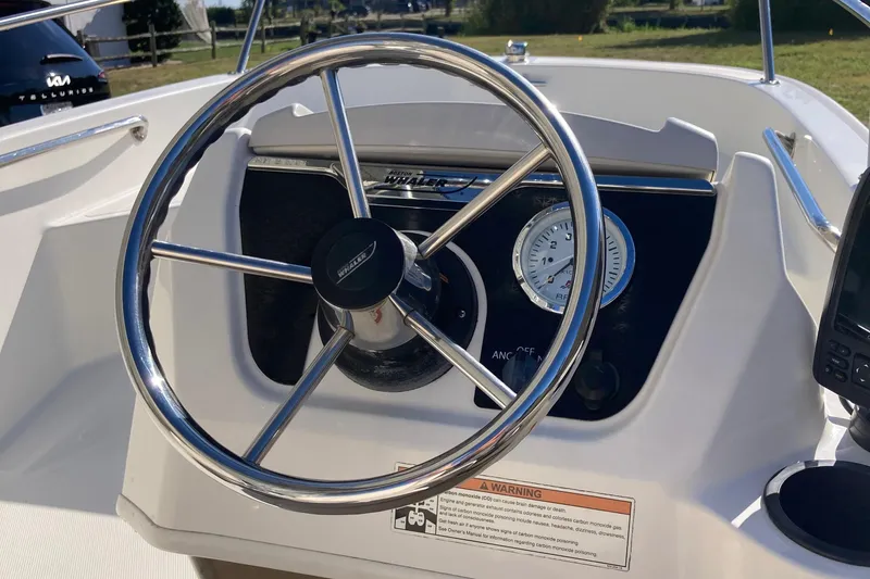Slide: The Image of Steering wheel and dashboard of 2019 Boston Whaler 130 Super Sport boat. - 2