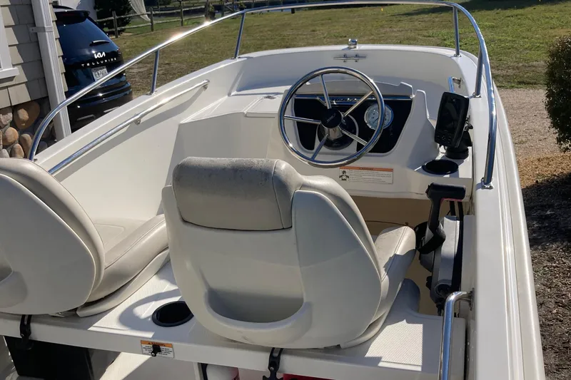 Slide: The Image of 2019 Boston Whaler 130 Super Sport boat interior with steering wheel and seating. - 3