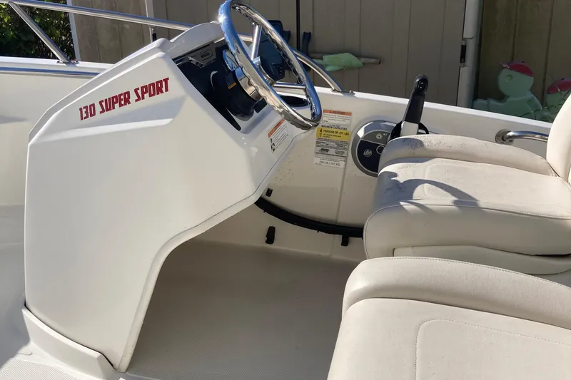 Slide: The Image of 2019 Boston Whaler 130 Super Sport interior with steering wheel and seating. - 6