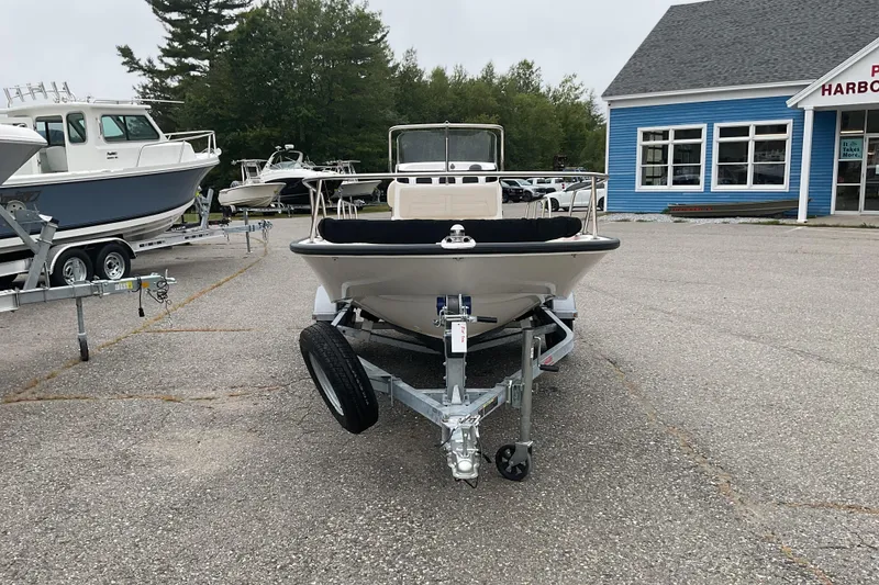 Slide: The Image of 2024 Boston Whaler 150 Montauk boat on trailer in dealership lot. - 2
