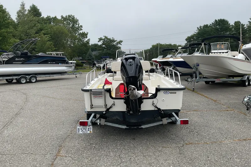 Slide: The Image of 2024 Boston Whaler 150 Montauk boat on trailer in a marina parking lot. - 6
