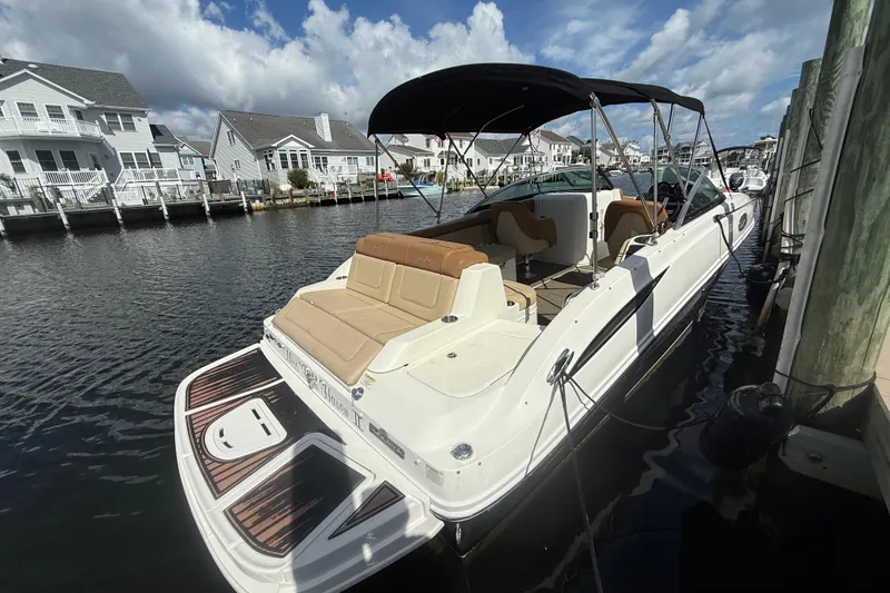 Slide: The Image of 2014 Sea Ray 260 Sundeck boat docked by waterfront homes under a blue sky. - 15