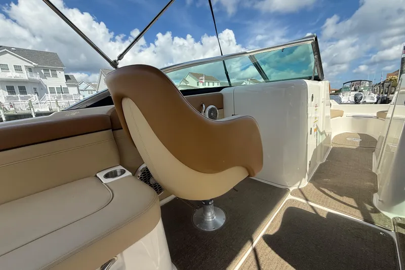 Slide: The Image of 2014 Sea Ray 260 Sundeck interior with tan seating and open deck view. - 16