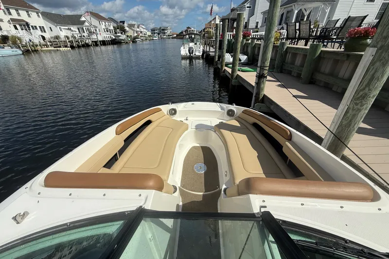 Slide: The Image of 2014 Sea Ray 260 Sundeck boat docked in a scenic waterfront area. - 20