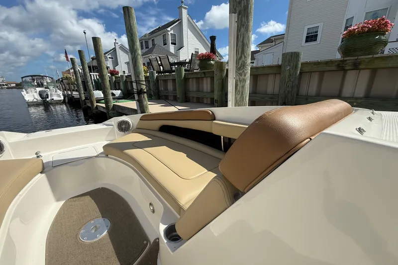 Slide: The Image of 2014 Sea Ray 260 Sundeck boat interior with tan seating at a dockside marina. - 22