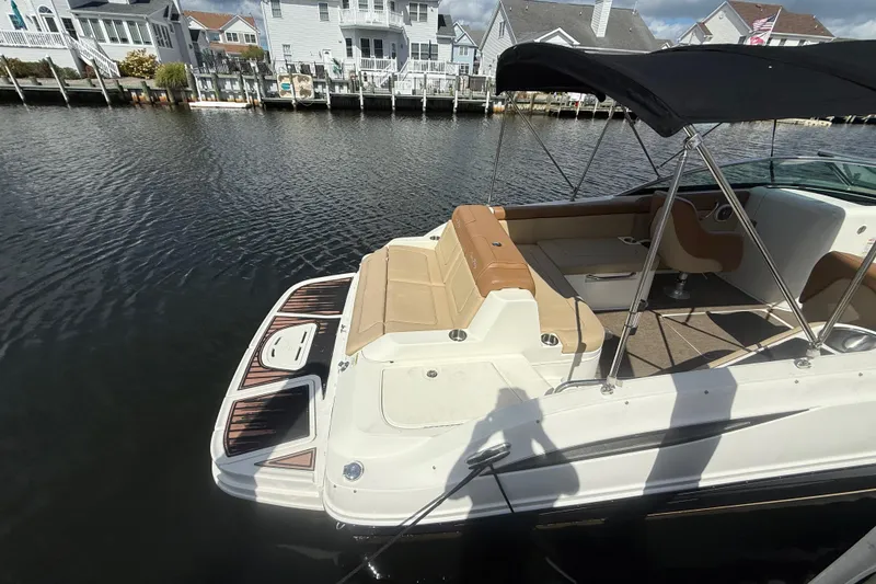 Slide: The Image of 2014 Sea Ray 260 Sundeck boat docked, featuring spacious seating and canopy. - 4