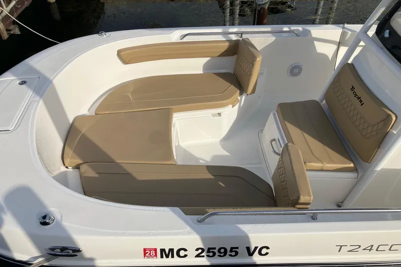 Slide: The Image of 2025 Bayliner Trophy T24CC boat interior with tan cushioned seating and sleek design. - 6