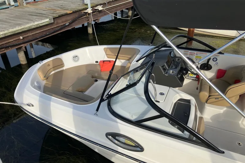 Slide: The Image of 2024 Bayliner VR6 Bowrider OB with spacious seating and sleek design at a dock. - 2