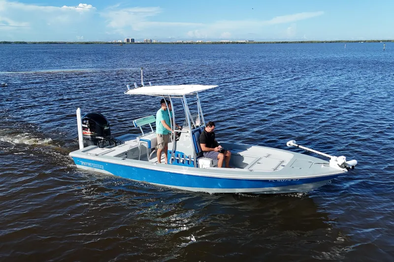 The Image of 2014 Pathfinder 2200 TRS boat cruising on open water with two passengers. - 0