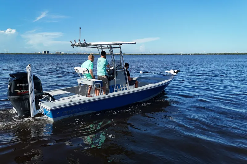 Slide: The Image of 2014 Pathfinder 2200 TRS boat on water with Yamaha engine, three people aboard. - 19