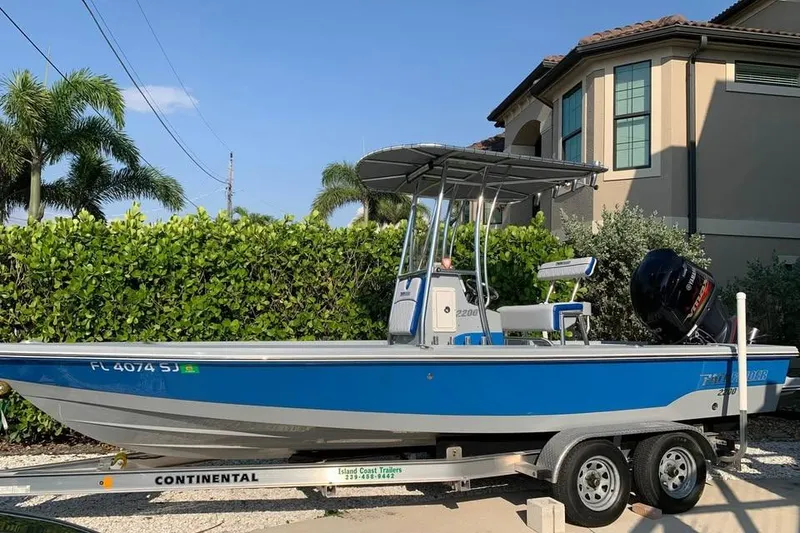 Slide: The Image of 2014 Pathfinder 2200 V Tournament Edition boat on trailer, parked near a house. - 25