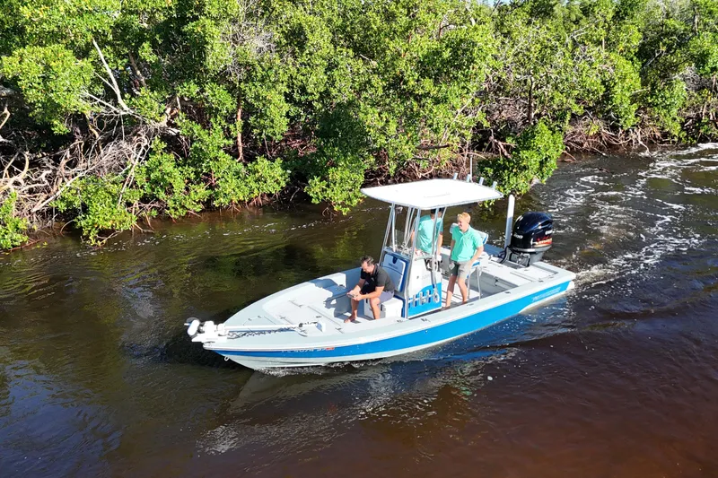 Slide: The Image of 2014 Pathfinder 2200 TRS boat navigating a river with lush green foliage. - 6