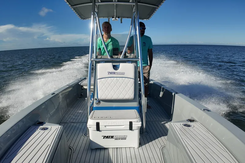 Slide: The Image of 2014 Pathfinder 2200 TRS boat cruising on open water with two passengers. - 7